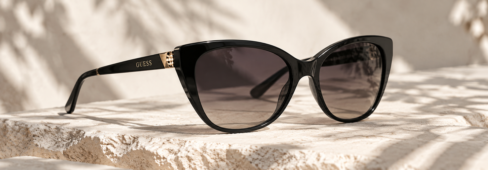 GUESS sunglasses on pale stone